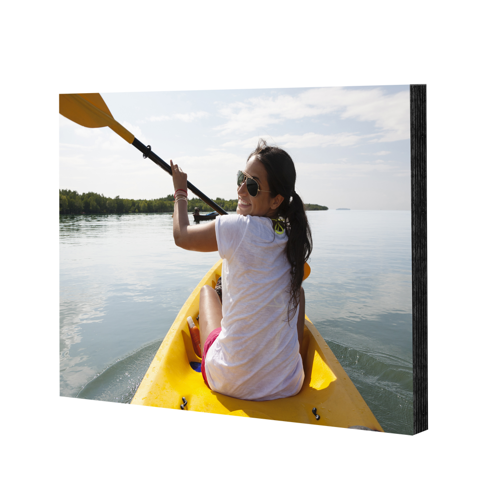 An elegant woman is paddling a kayak in the water with Fuji Personalized Photo Products Mounted Prints.