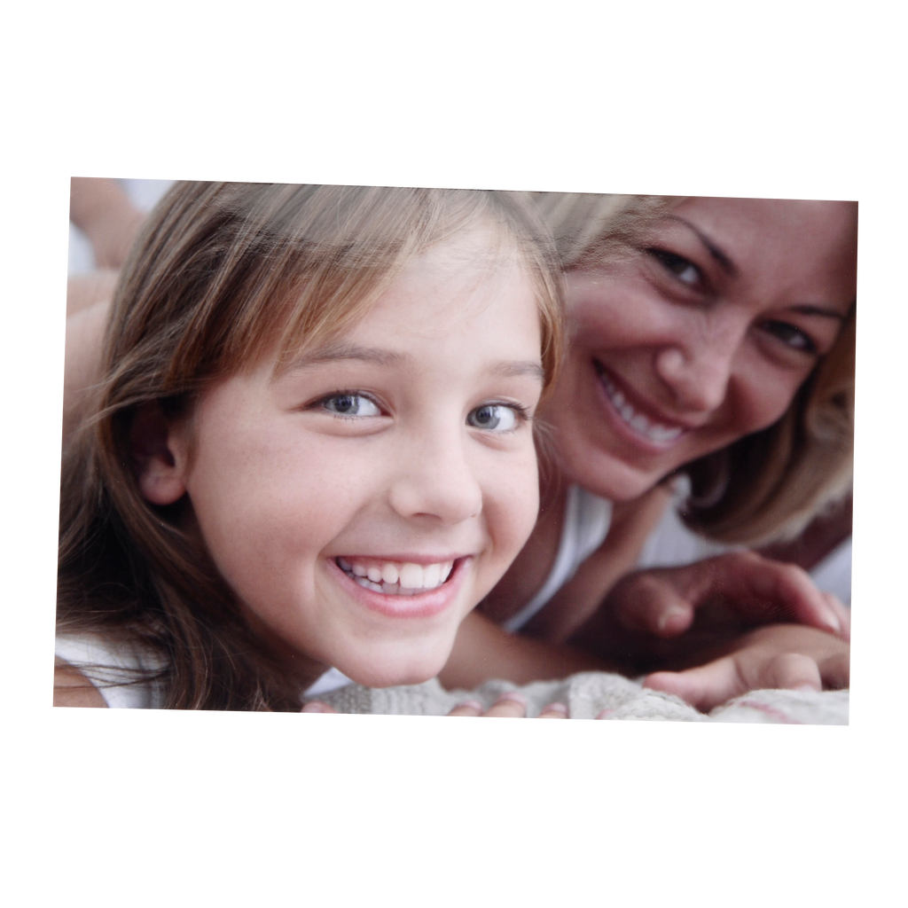 A young girl is laying on a bed with her mother, both captured in various sizes on Fuji Personalized Photo Products small format prints.
