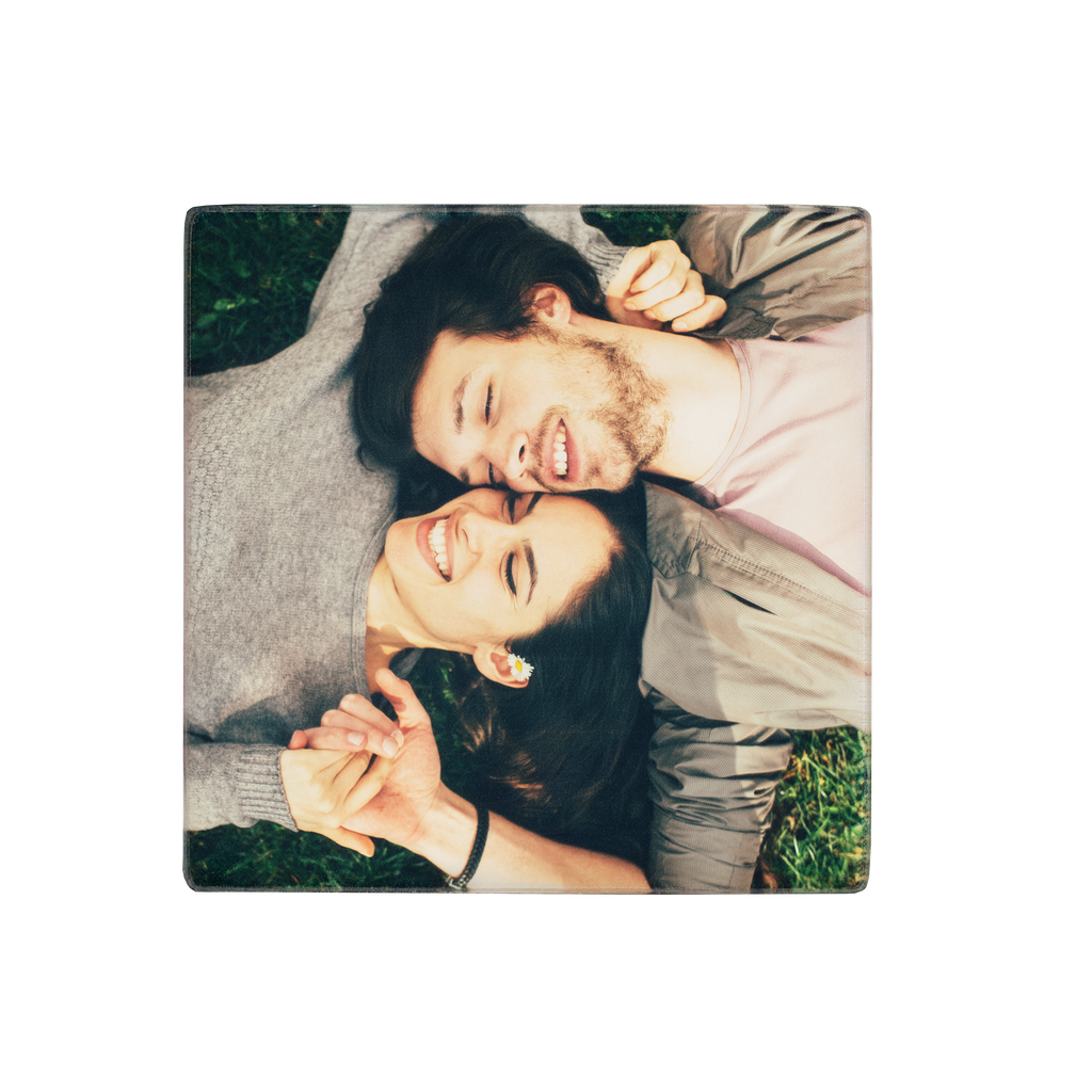 Two individuals lying on grass with their heads together, smiling in a Fuji Personalized Photo Products Acrylic Square Photo Magnet.