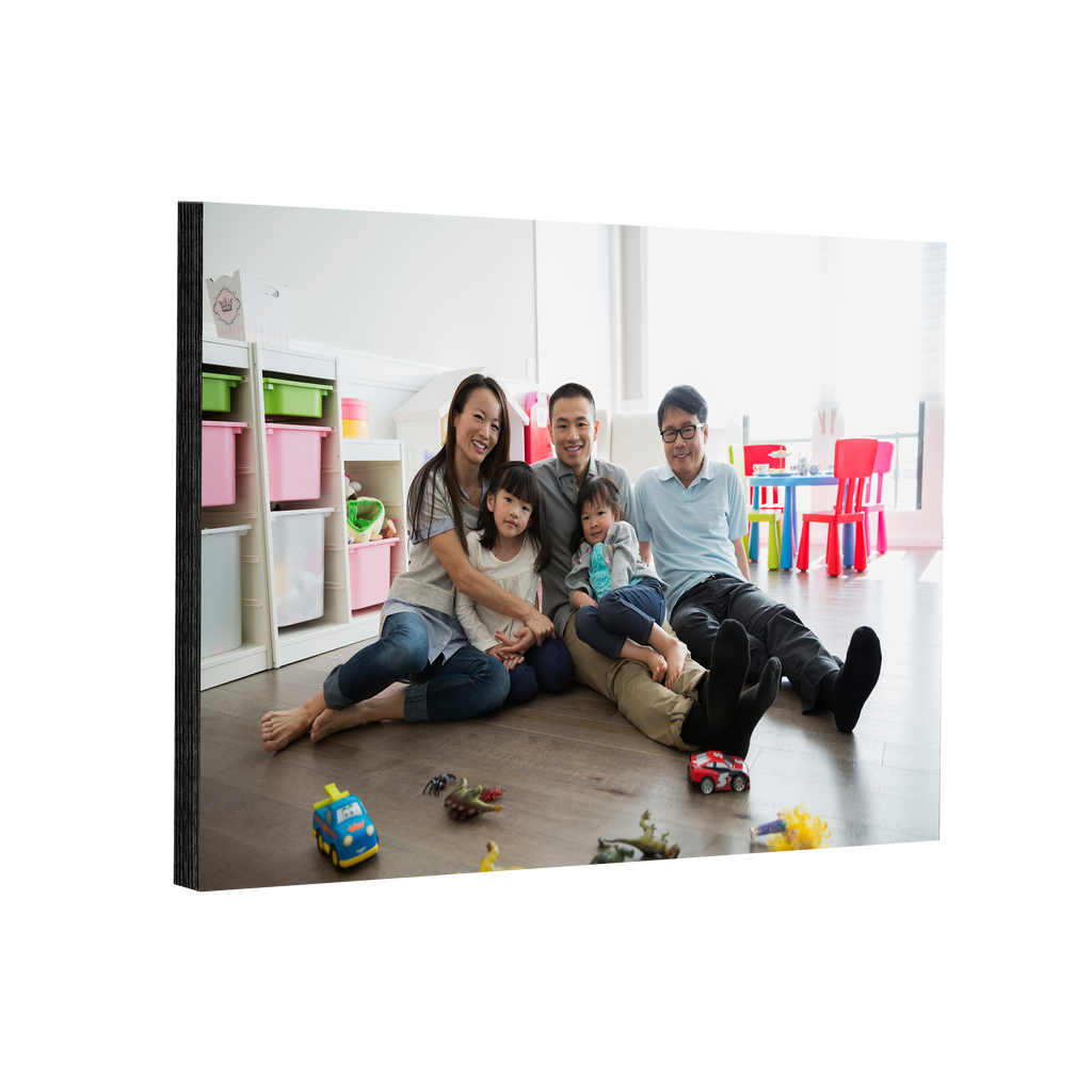 A family sits on the floor in a room with elegant Fuji Personalized Photo Products mounted prints and toys.