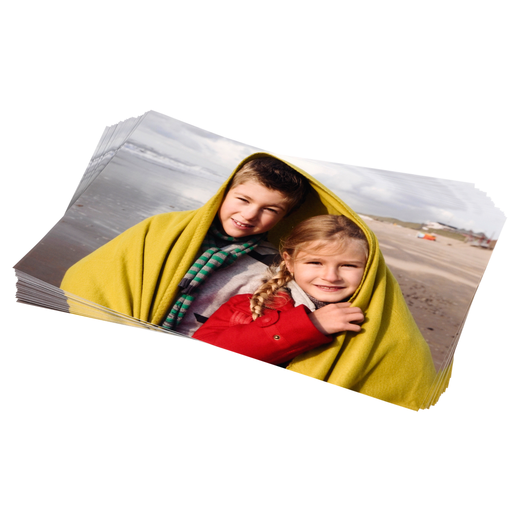 Two children are wrapped in a Fuji Personalized Photo Products small format print blanket on a beach.
