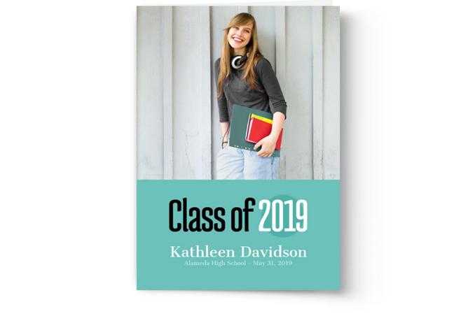 A photo of a woman holding a Photo Book Press graduation announcement card with the words class of 2019.