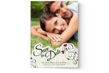 A custom printed Save the Date Card Printing from Photo Book Press with a couple in the grass.