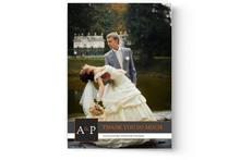A bride and groom in a cheerful pose outdoors with the groom holding the bride in a dip, both smiling broadly, capturing a perfect moment for Photo Book Press's Create Your Own Photo Wedding Cards.