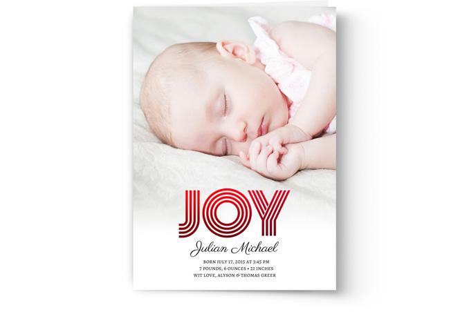 Sleeping newborn baby with a birth announcement overlay stating "joy" and personal details, featured in a custom printed Birth Announcement Photo Card by PhotoBook Press.